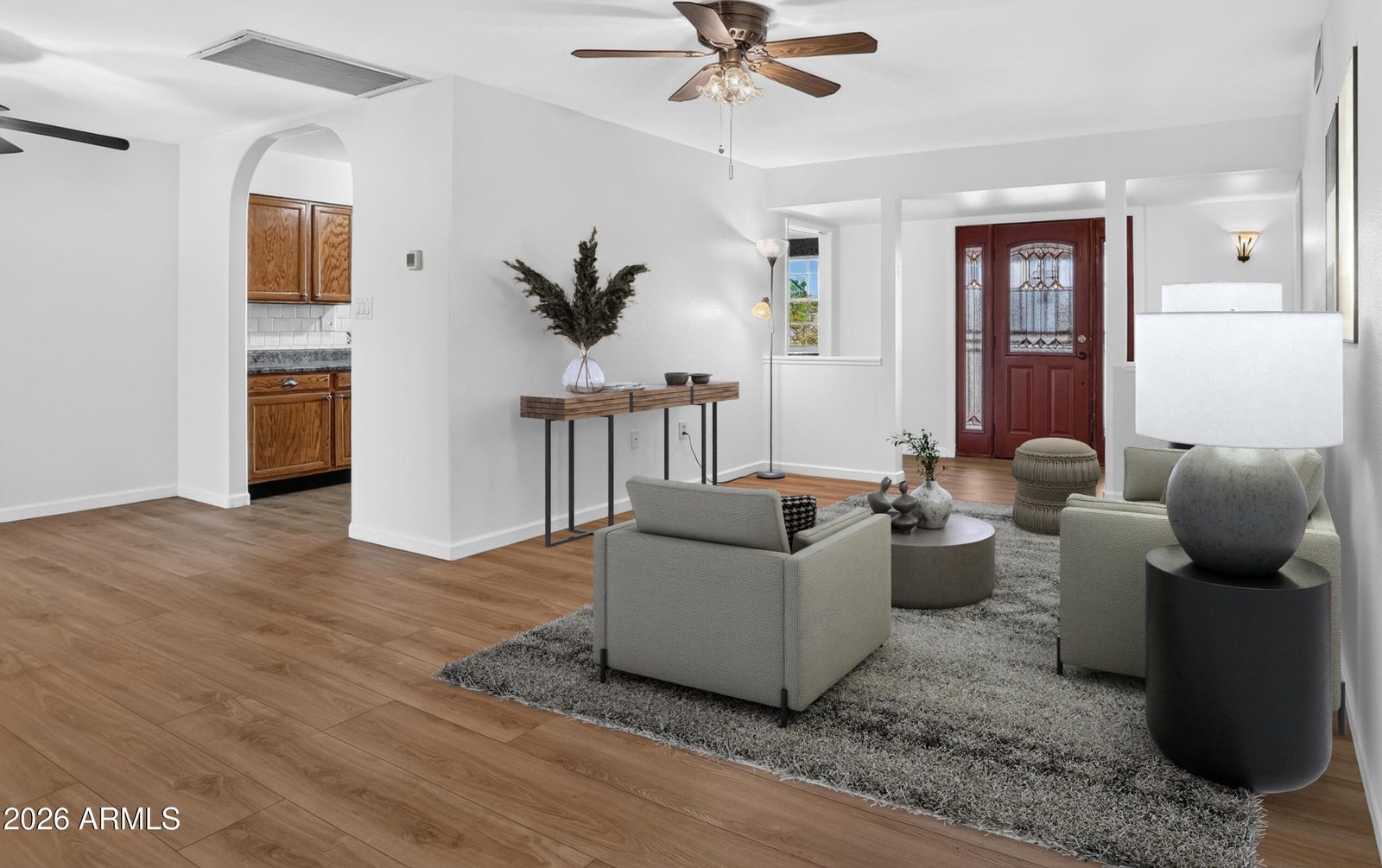Virtually staged living room with wood-look flooring at 10613 W Meade Dr